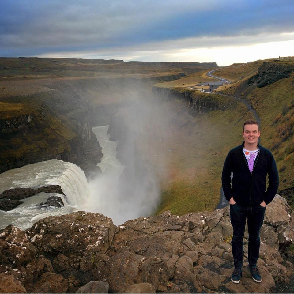 Calan Hobbs standing on the rocks above a waterfall and canyon in Iceland in 2014