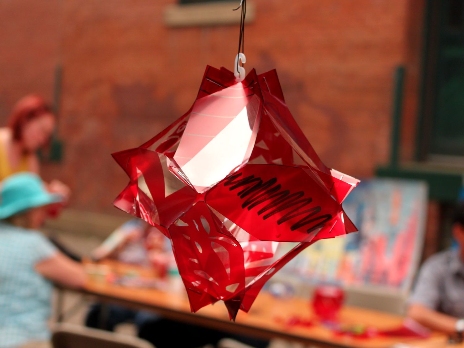 Hand-cut paper decorations above a community art table at an outdoor Edmonton event — community engagement Edmonton