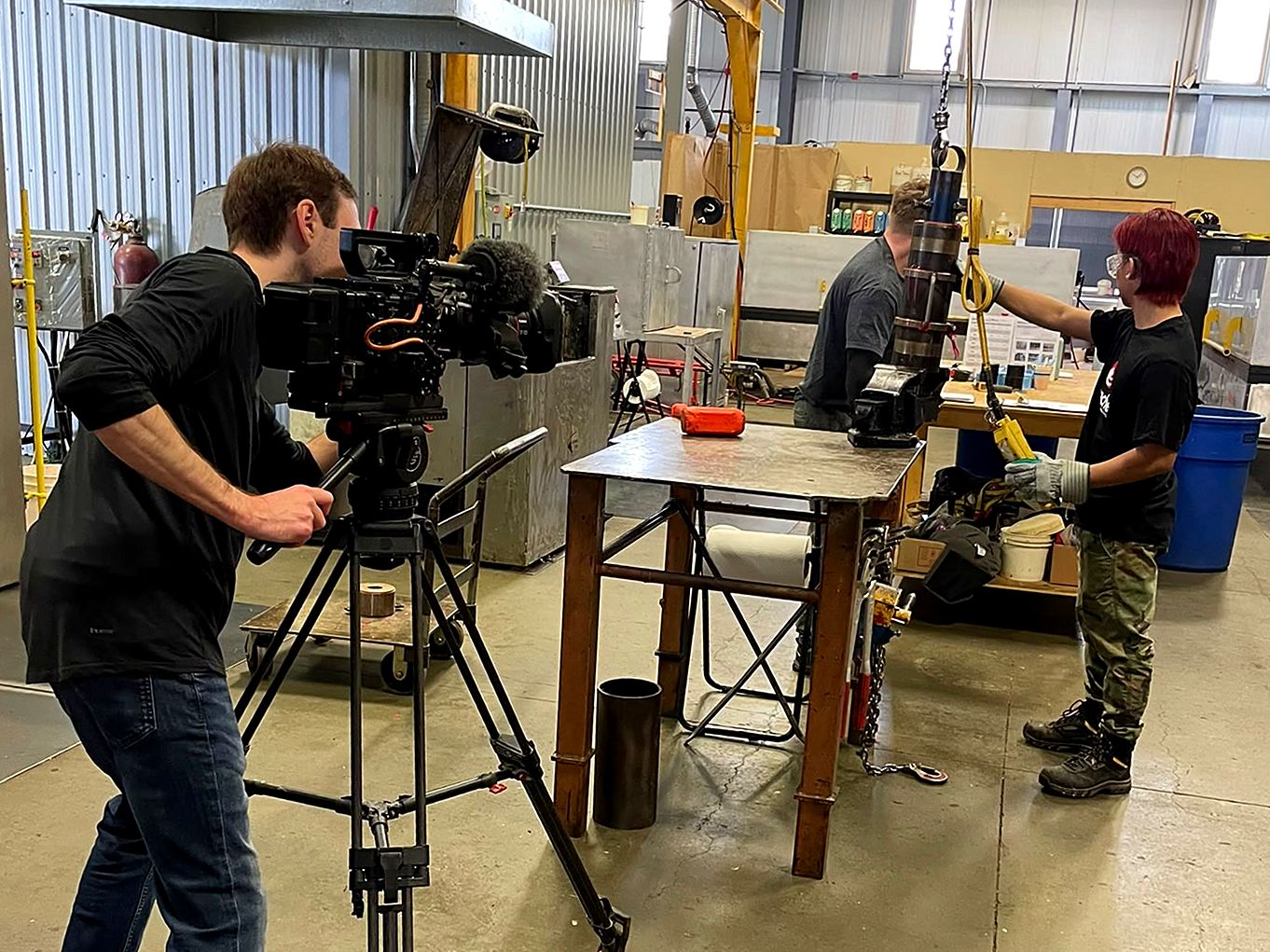 A camera operator filming fabricators at work in an Edmonton shop — video production for small business Edmonton
